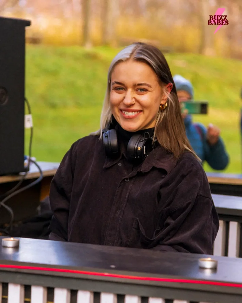 DJ standing behind a booth at a Buzz Babes outdoor music event