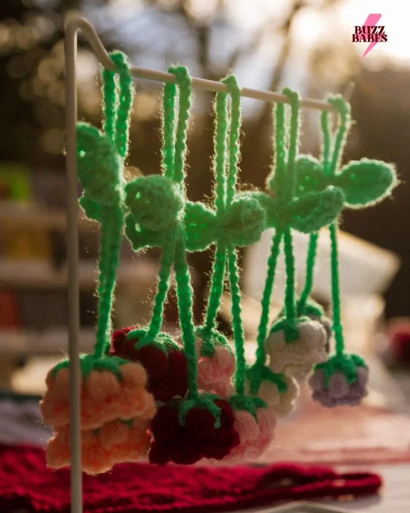 Handmade crochet accessories hanging at a Buzz Babes market